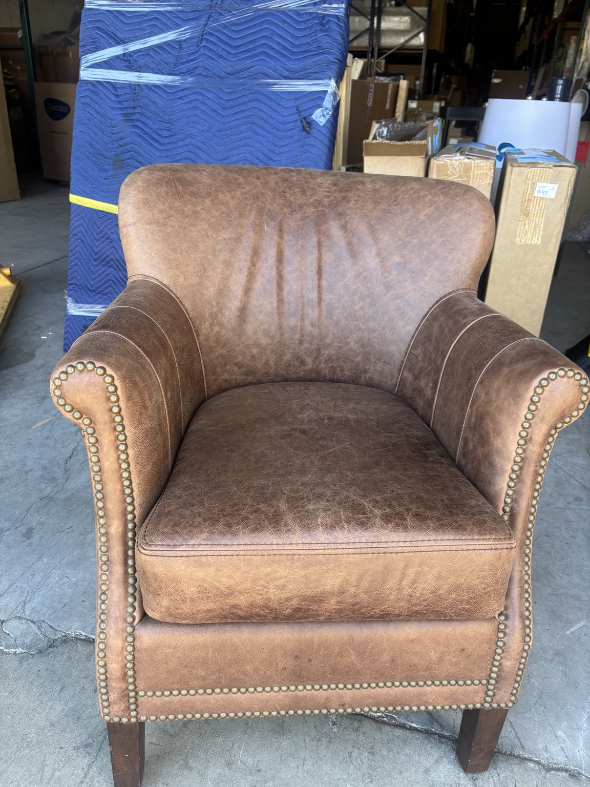 Leather chair with faded, uneven color before restoration