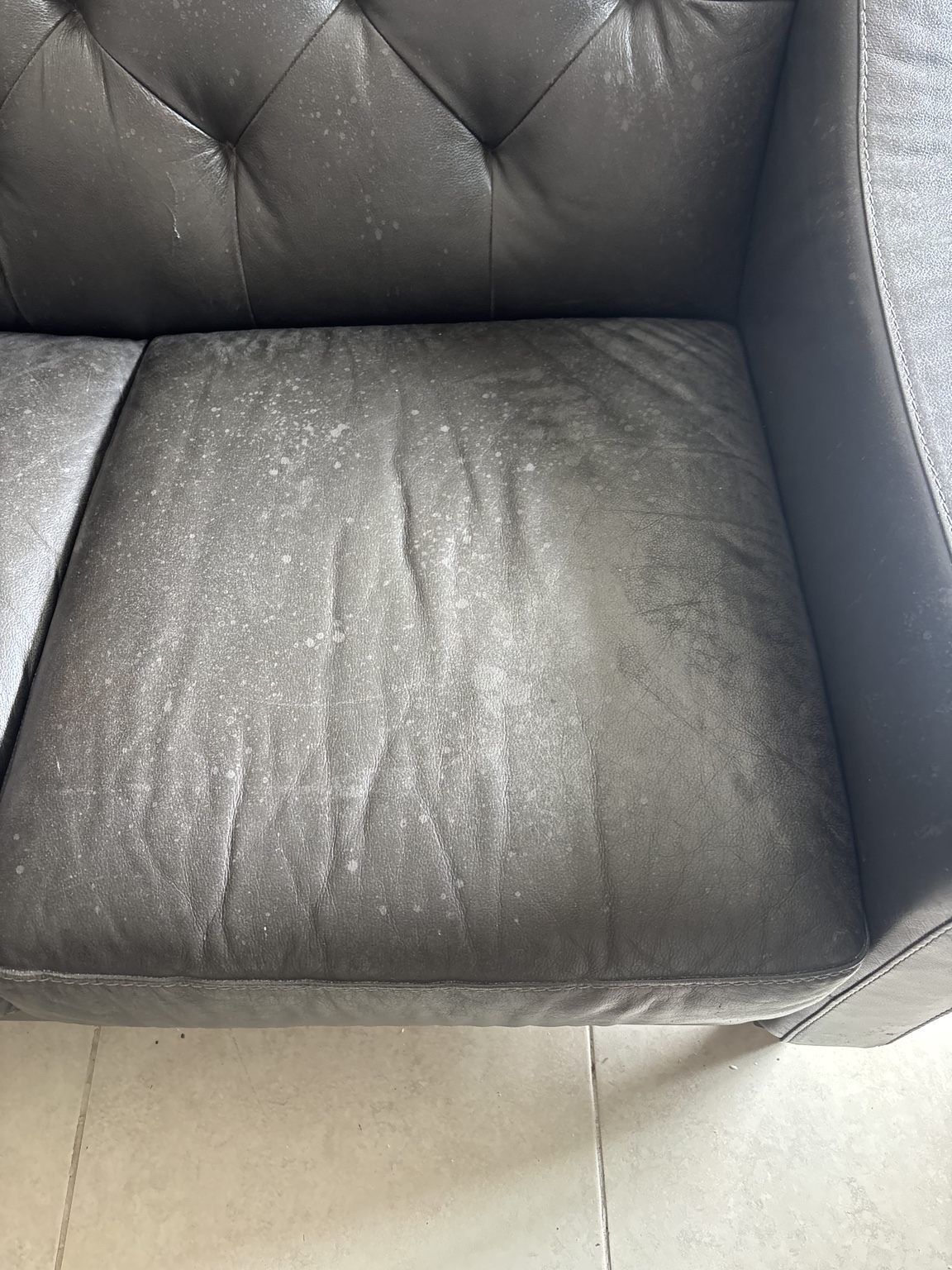 Leather sofa cushion with buildup before cleaning